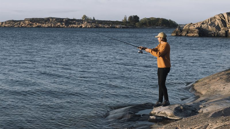 mies kalastaa Itämeren rannalla