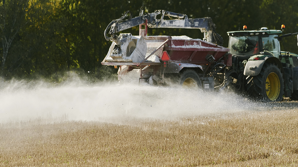 traktori levittää kipsiä peltoon