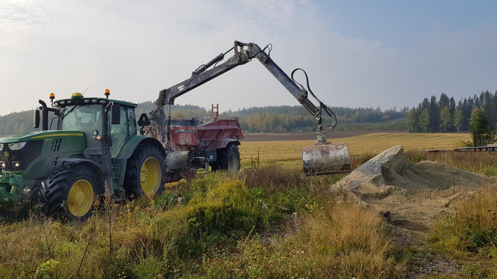 Traktori levittää luonnonkipsiä pellolle