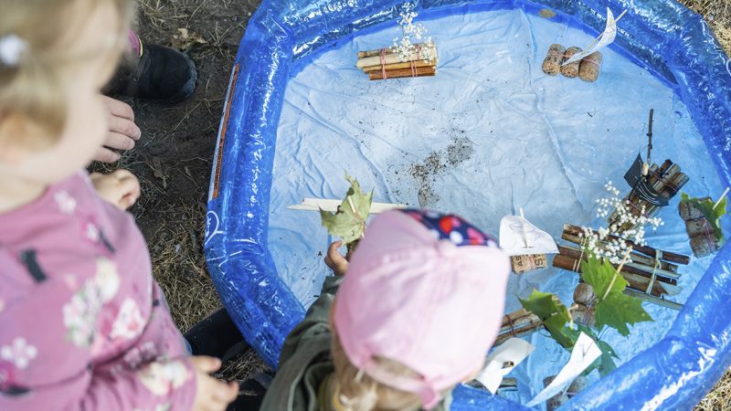 lapset uittavat itse tehtyjä veneitä kumisessa uima-altaassa