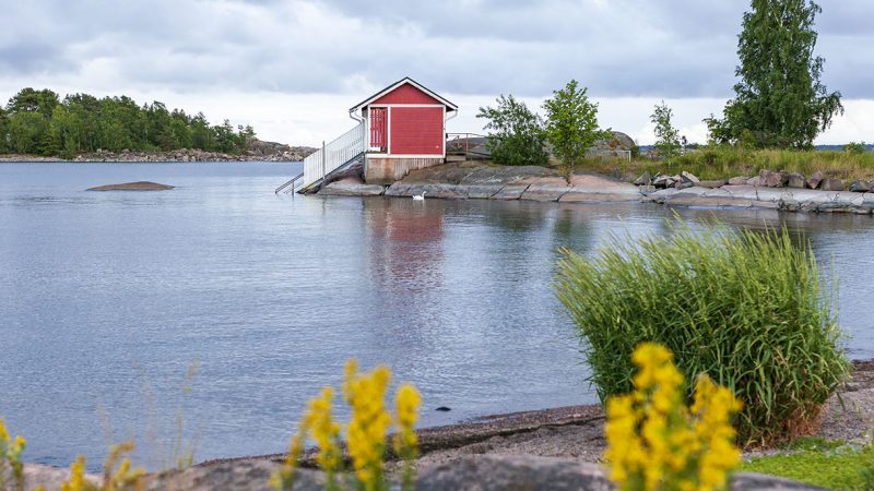 punainen mökki meren rannalla