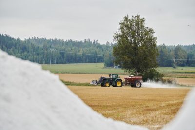 Traktori levittää kipsiä pellolle