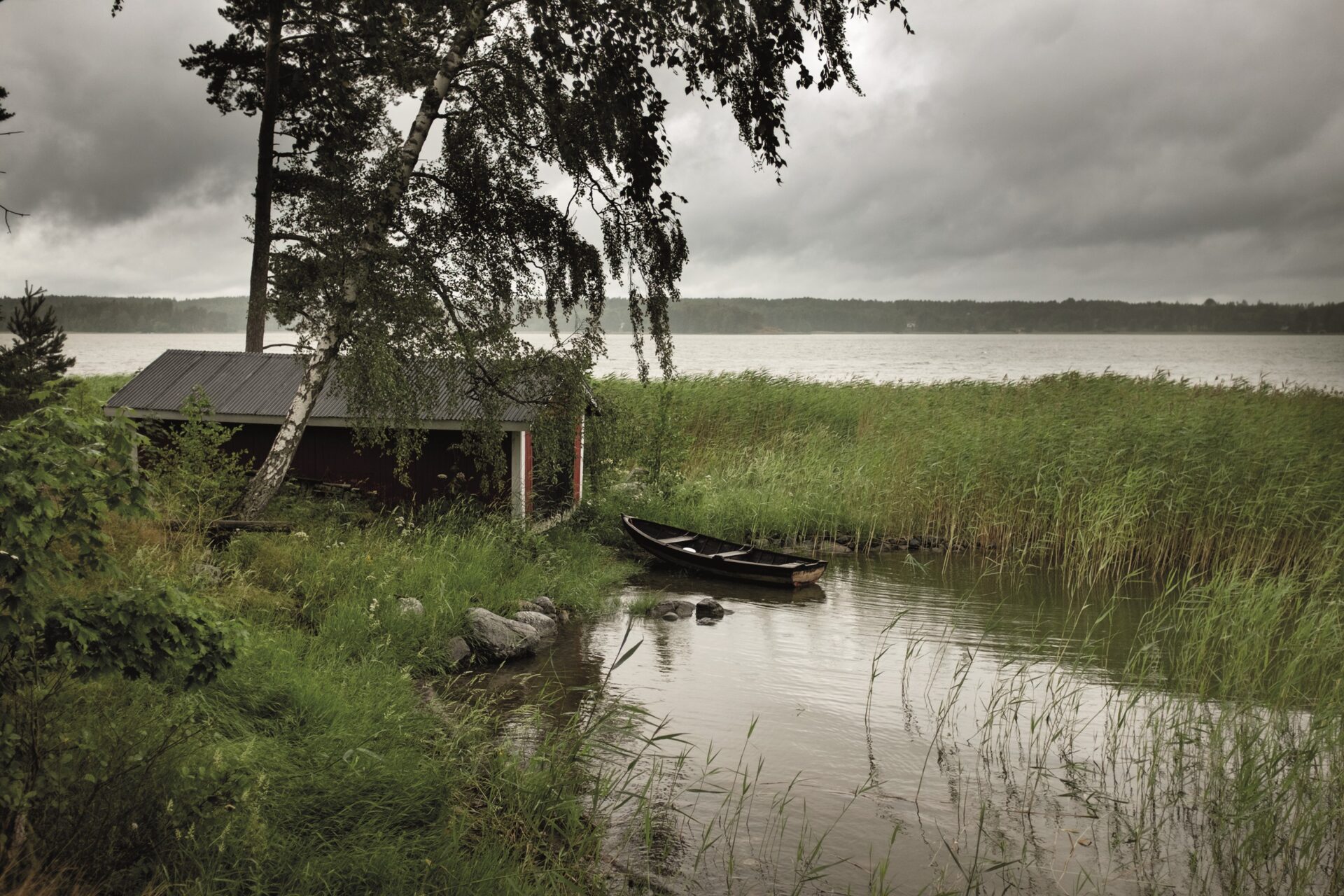 puuvene ja venevaja sateisessa ja myrskyisässä säässä