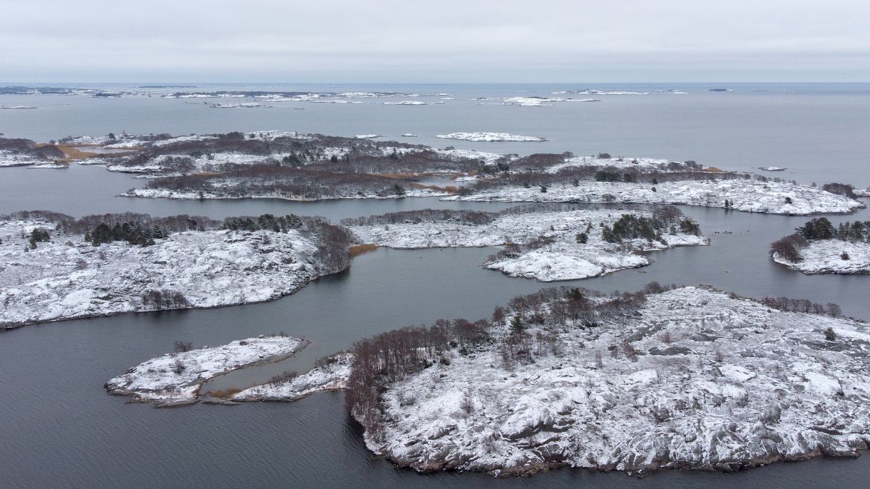 meressä näkyviä saaria, joissa hento lumipeite