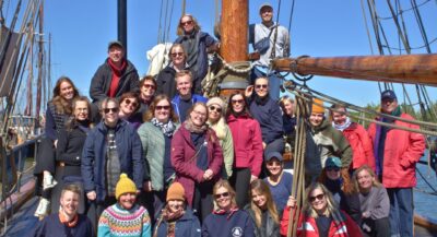 ryhmäkuva ihmisistä vanhan purjelaivan kannella aurinkoisessa säässä