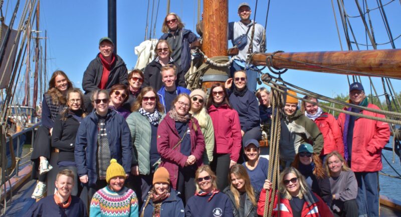 ryhmäkuva ihmisistä vanhan purjelaivan kannella aurinkoisessa säässä